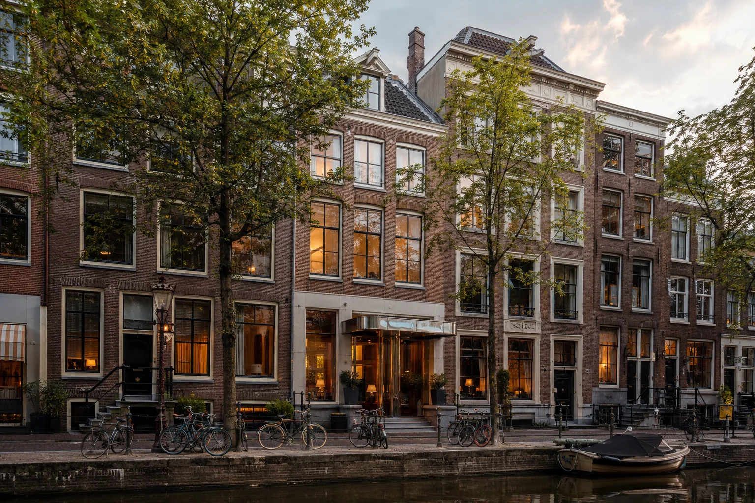 Bakstenen hotelconcept aan een Amsterdamse gracht in warm middaglicht
