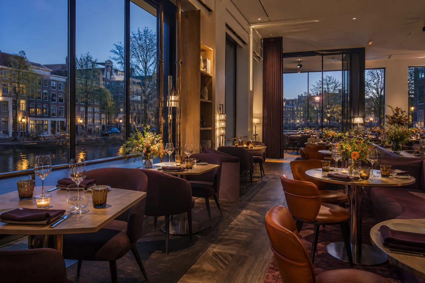 Restaurant met gedekte tafels en hoge ramen aan het water